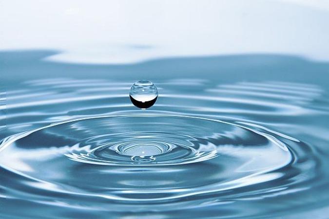 Wassertropfen fällt auf Wasserfläche